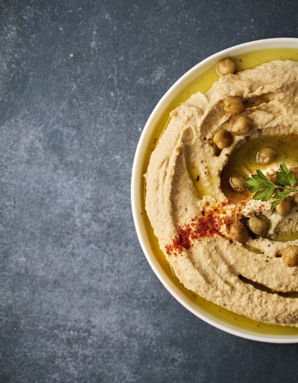 Hummus met olijfolie, paprikapoeder en peterselie