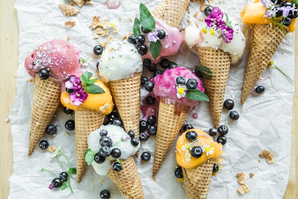 Kleurrijke ijscones met vers fruit en bloemen